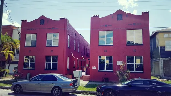 a red car parked in front of a building