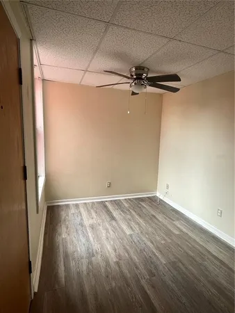 a view of room with hardwood floor and a ceiling fan