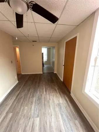 an empty room with wooden floor and windows