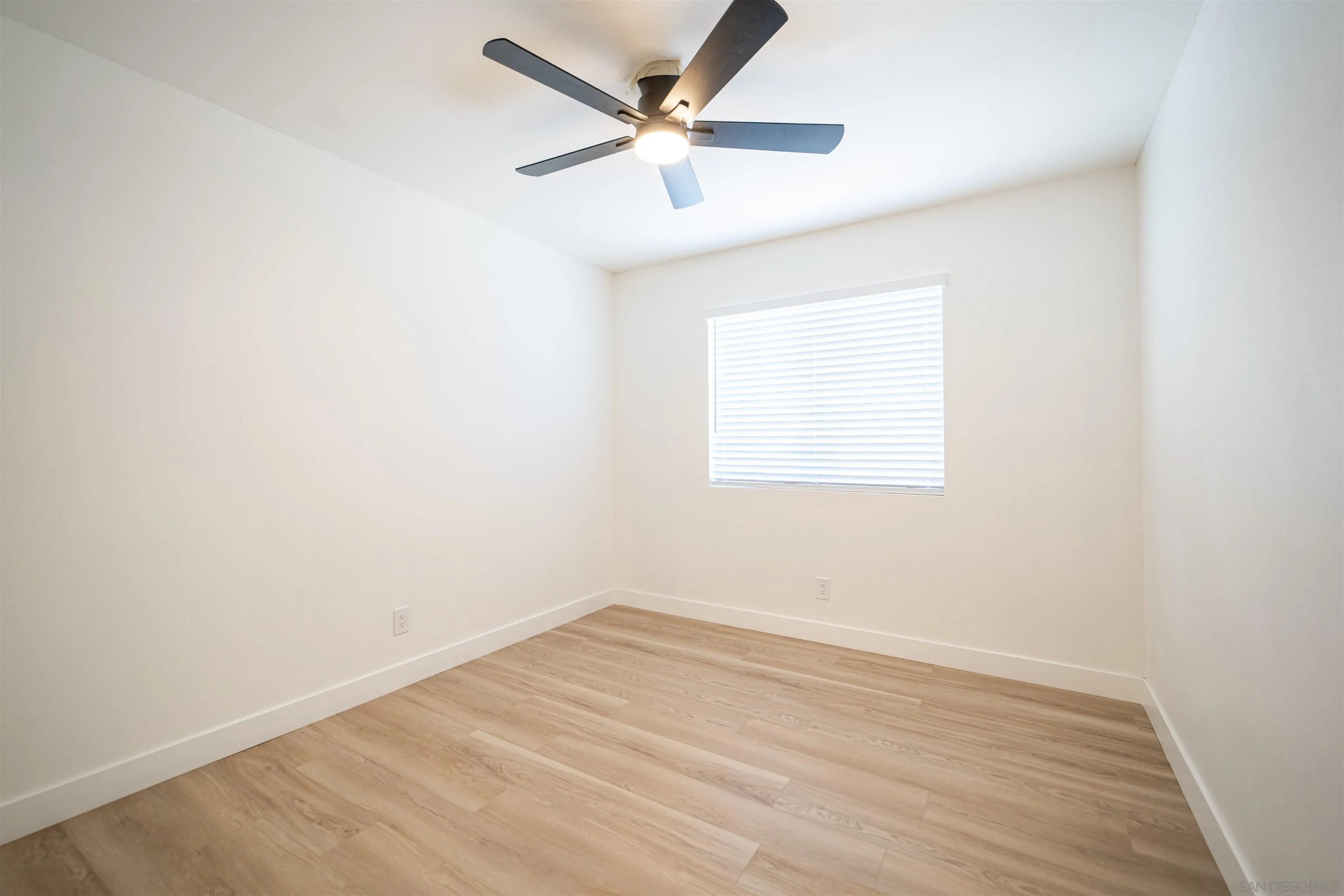 1306 West San Ysidro Boulevard, Unit D San Diego, CA 92173 - Photo 11 of 22 an empty room with a window and a ceiling fan