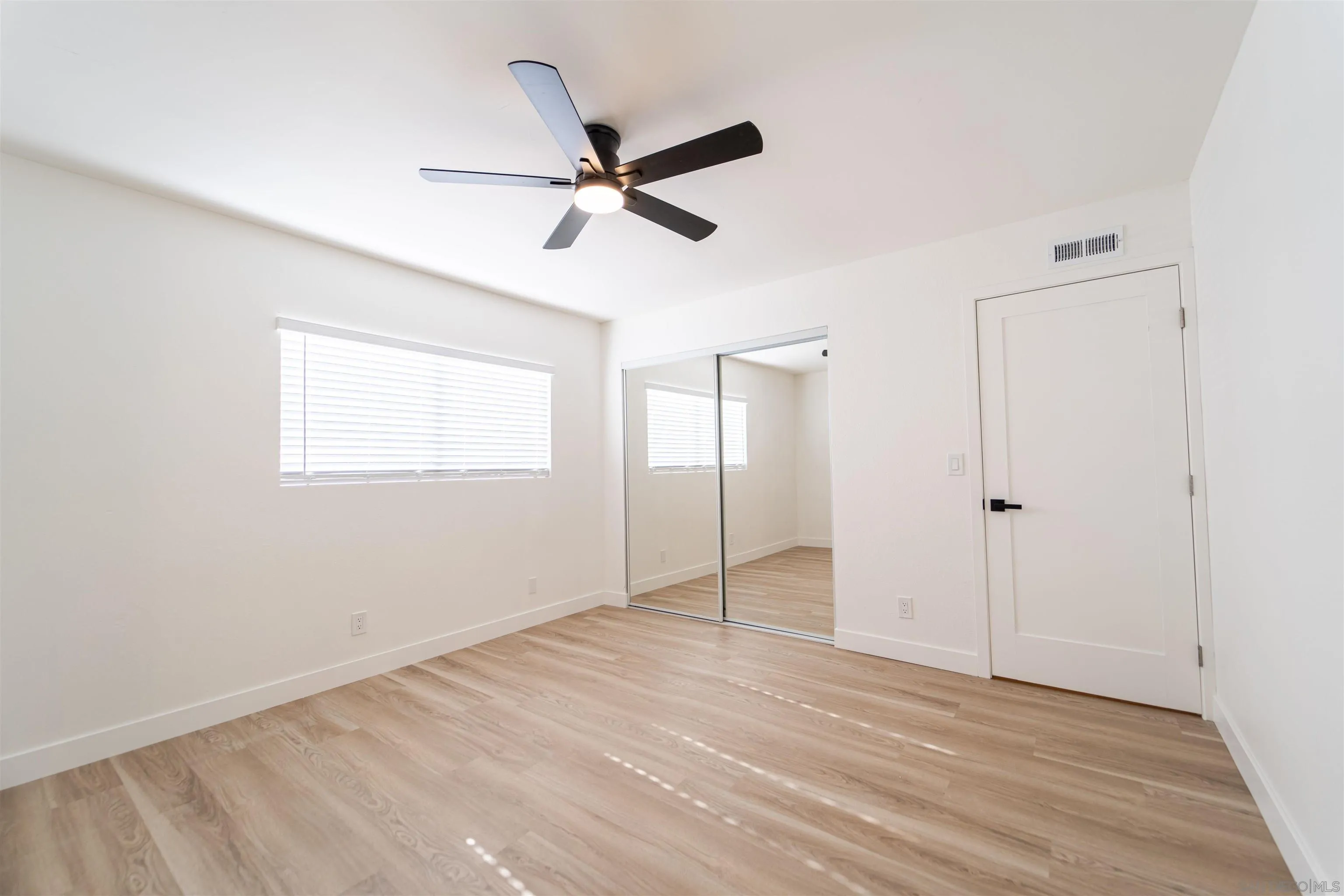 1306 West San Ysidro Boulevard, Unit D San Diego, CA 92173 - Photo 15 of 22 a view of a big room with wooden floor closet and windows