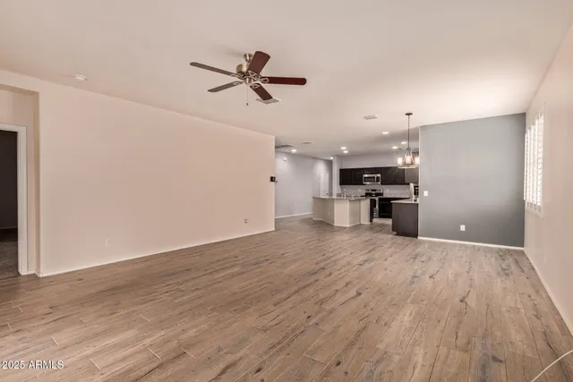 a view of empty room with wooden floor and window