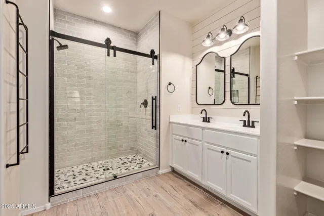 a bathroom with a double vanity sink mirror and shower