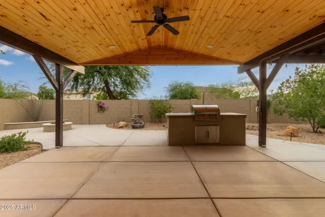 a view of a patio with a table and chairs under an umbrella