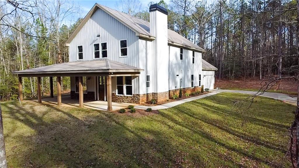 507 North Ridge Road Barnesville, GA 30204 - Photo 2 of 21 a view of a white house with a yard and table and chairs under an umbrella