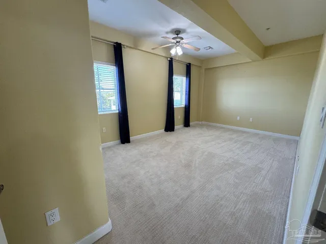 an empty room with a chandelier fan and a fan