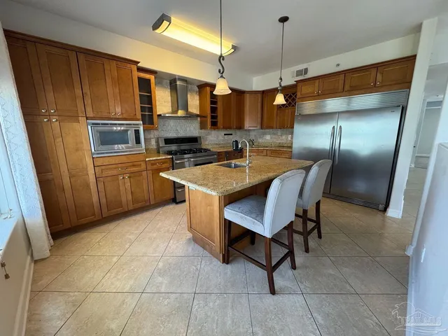 a kitchen with granite countertop a sink cabinets and stainless steel appliances