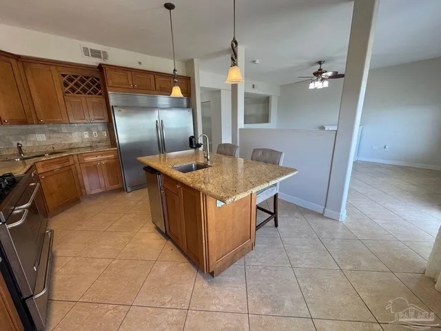 a kitchen with stainless steel appliances granite countertop a sink and a refrigerator