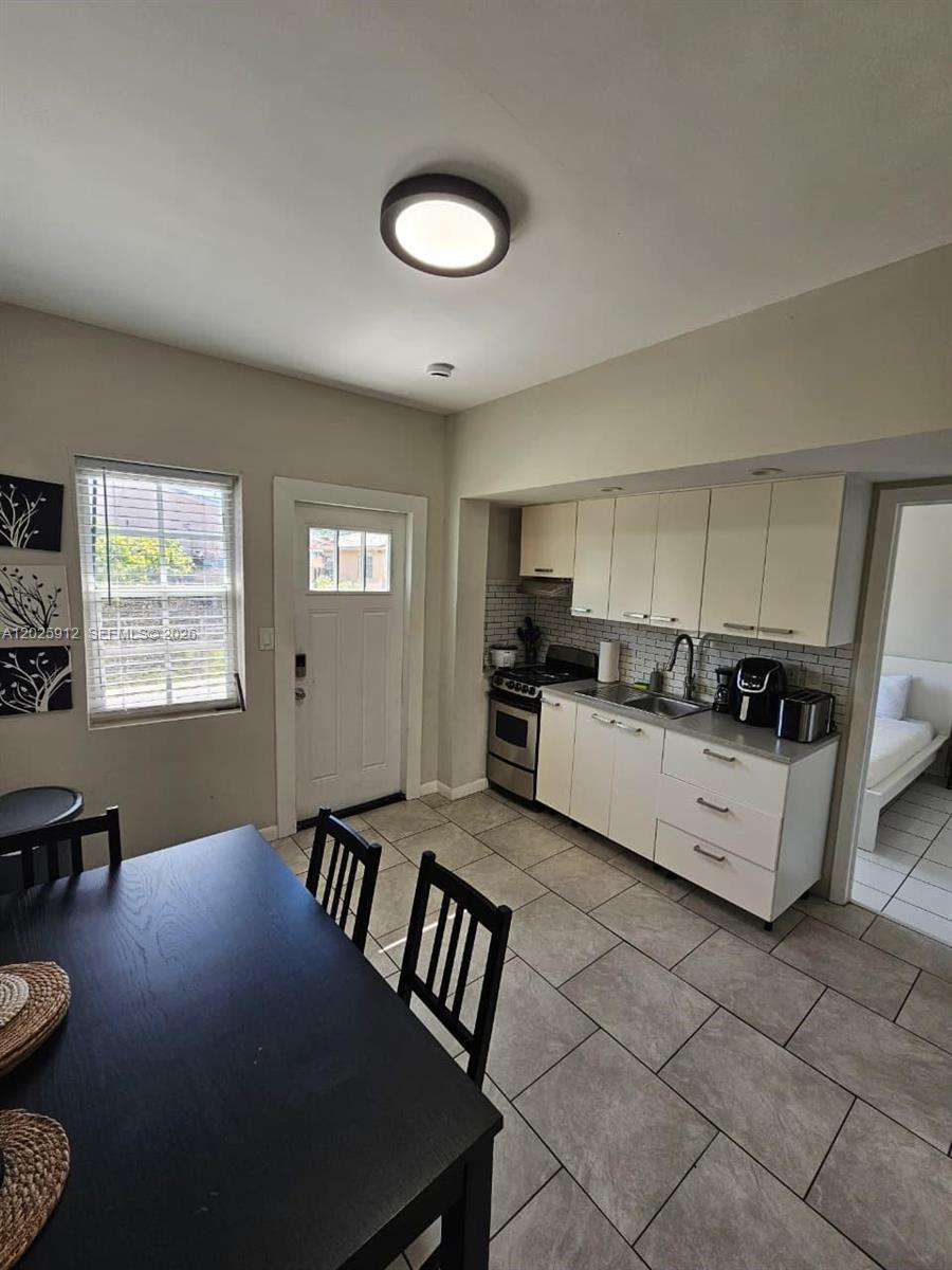2224 Southwest 11th Street, Unit 3 Miami, FL 33135 - Photo 5 of 15 a kitchen with a stove a sink and white cabinets