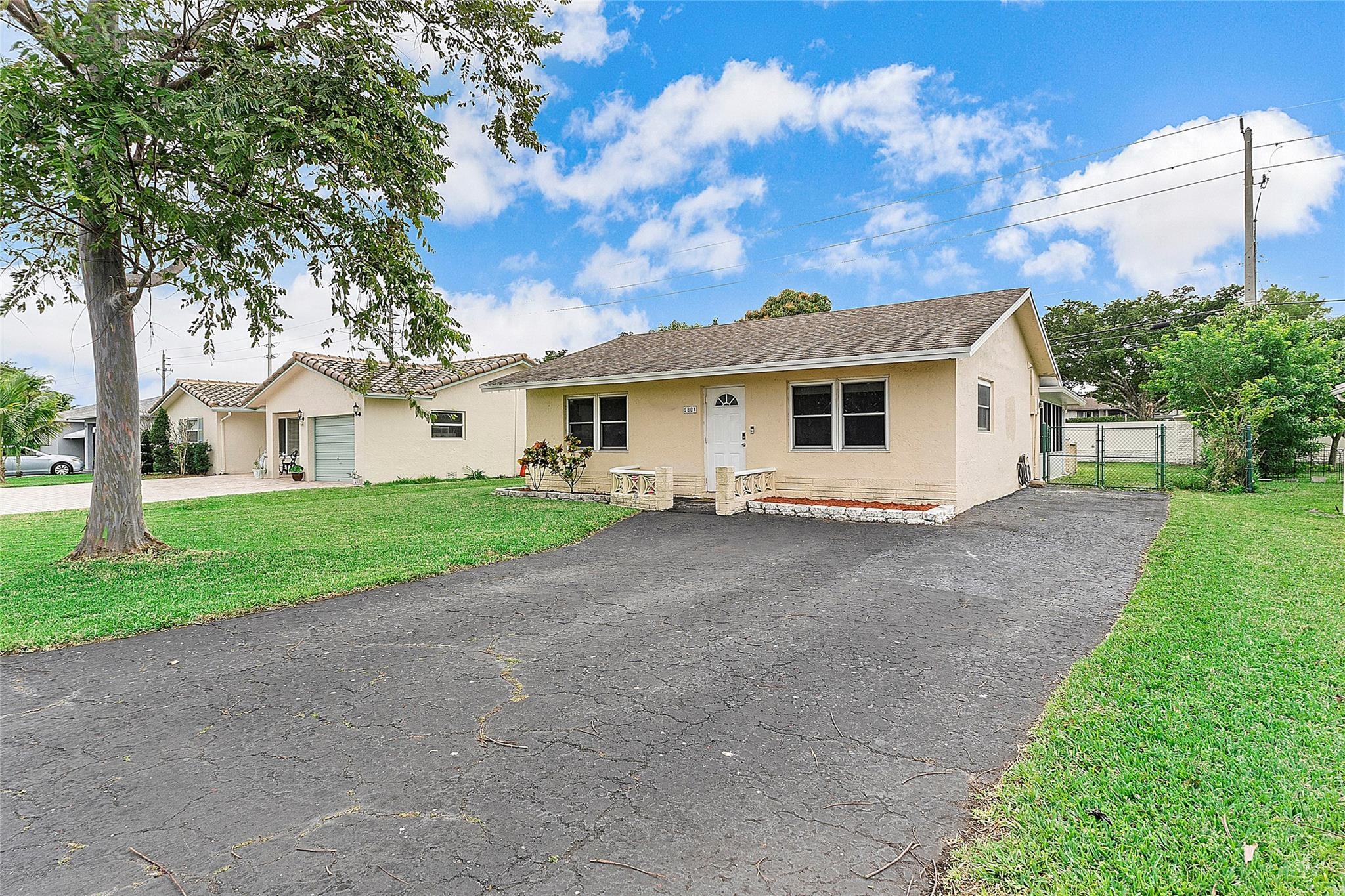 a view of a house with a yard and large tree