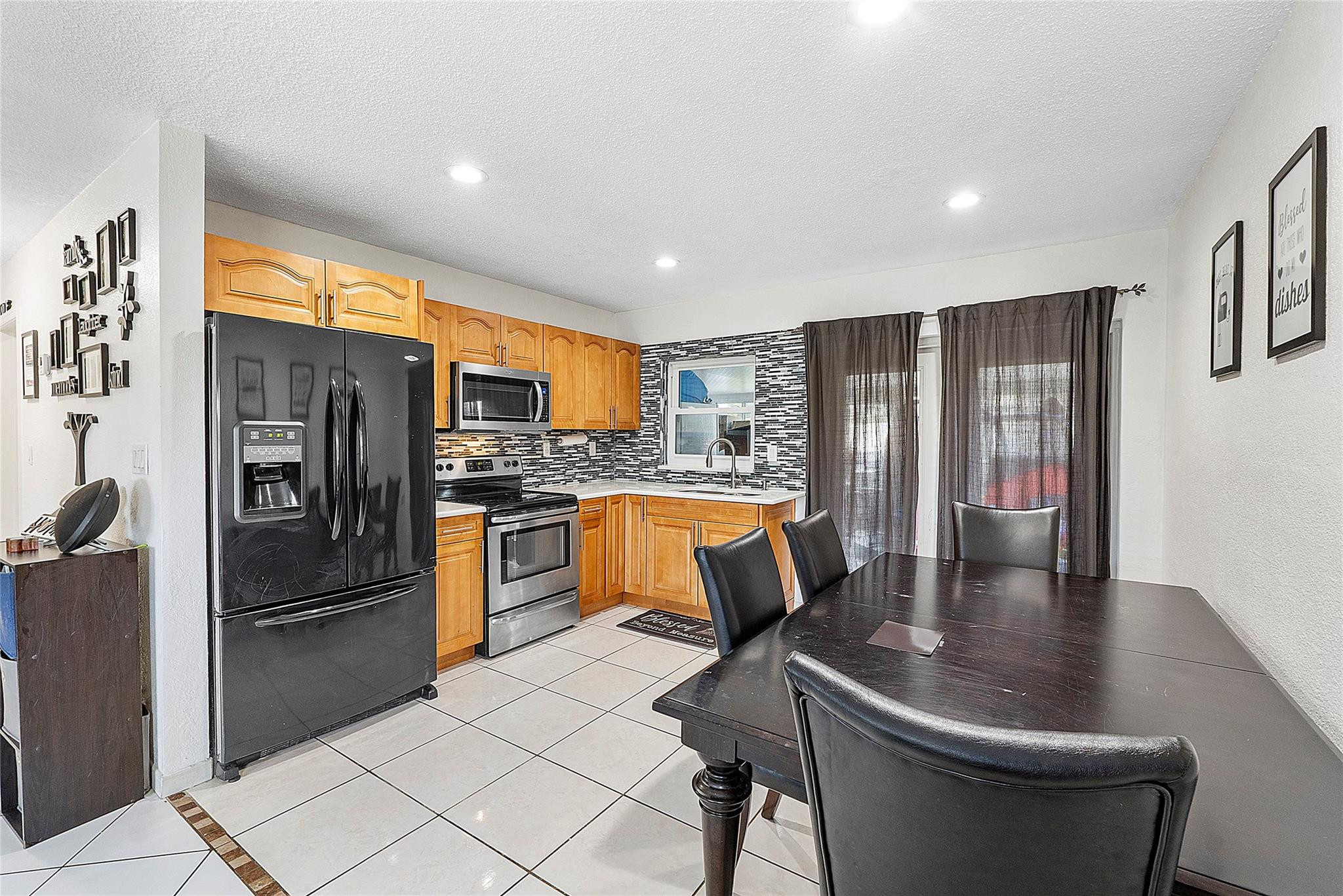 9804 Northwest 70th Street Tamarac, FL 33321 - Photo 2 of 12 a kitchen with stainless steel appliances granite countertop a refrigerator a sink a stove and island