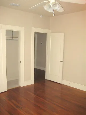 an empty room with wooden floor and closet area