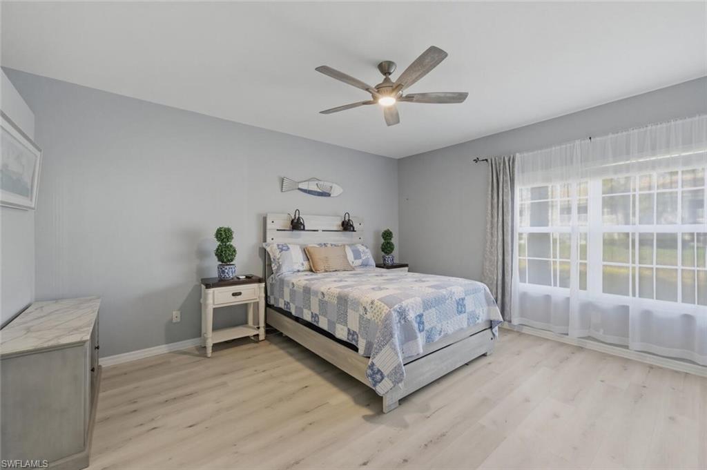 6899 Rain Lily Road, Unit 103 Naples, FL 34109 - Photo 17 of 39 Bedroom with light wood-style flooring and ceiling fan