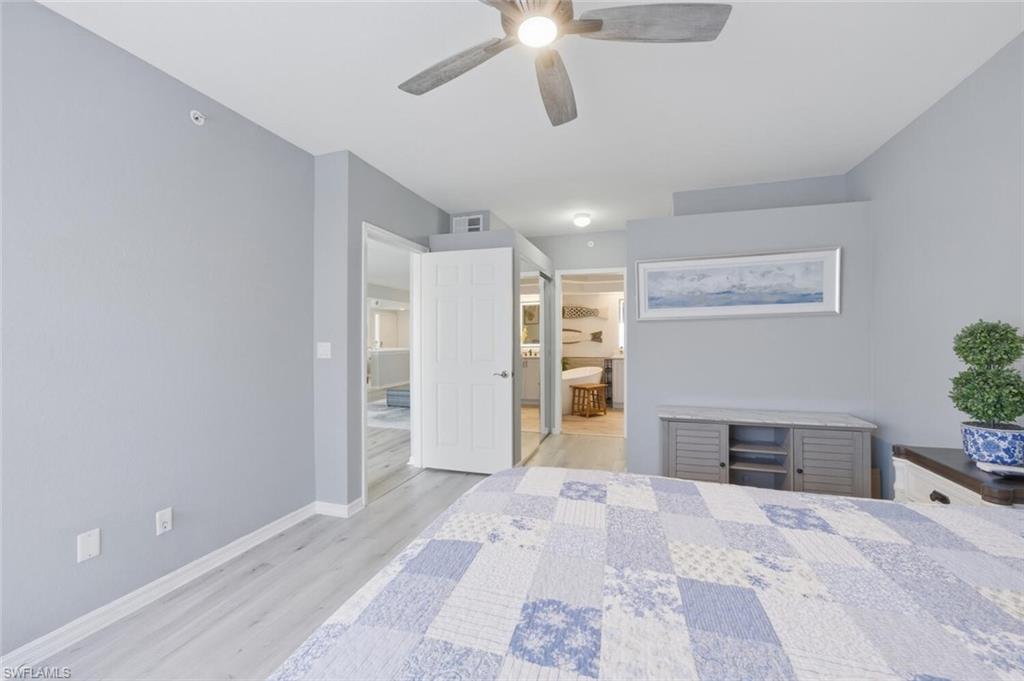 6899 Rain Lily Road, Unit 103 Naples, FL 34109 - Photo 18 of 39 Bedroom with light wood-type flooring, ensuite bath, and ceiling fan