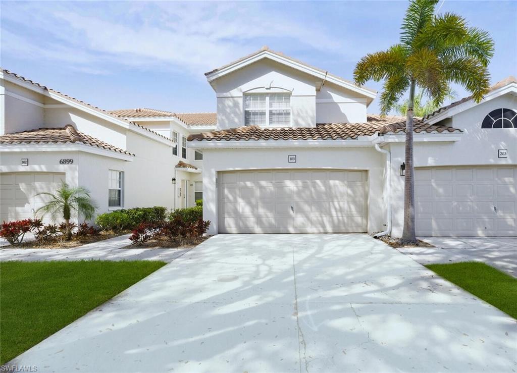 6899 Rain Lily Road, Unit 103 Naples, FL 34109 - Photo 2 of 39 Mediterranean / spanish-style house featuring stucco siding, driveway, a garage, and a tile roof