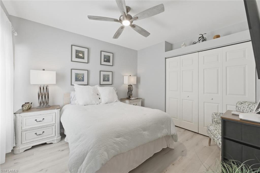 6899 Rain Lily Road, Unit 103 Naples, FL 34109 - Photo 21 of 39 Bedroom featuring light wood-style flooring, a closet, and ceiling fan