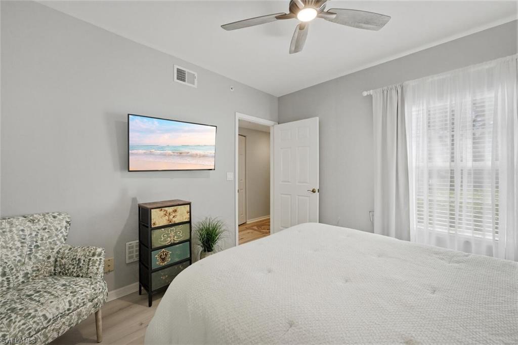 6899 Rain Lily Road, Unit 103 Naples, FL 34109 - Photo 22 of 39 Bedroom with light wood-style floors and a ceiling fan