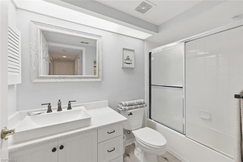 6899 Rain Lily Road, Unit 103 Naples, FL 34109 - Photo 23 of 39 Full bathroom featuring vanity and bath / shower combo with glass door