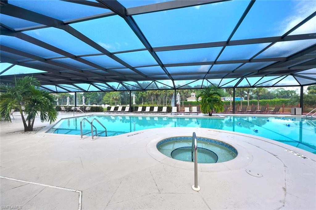 6899 Rain Lily Road, Unit 103 Naples, FL 34109 - Photo 33 of 39 Community pool featuring a hot tub, a patio area, and glass enclosure