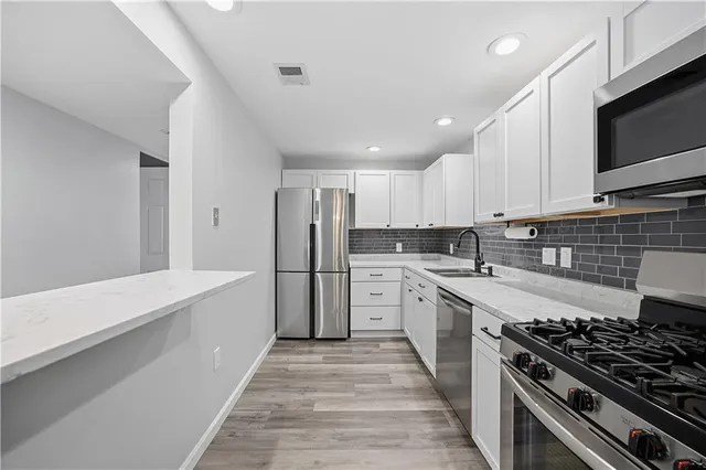 a large kitchen with stainless steel appliances granite countertop a stove and a sink