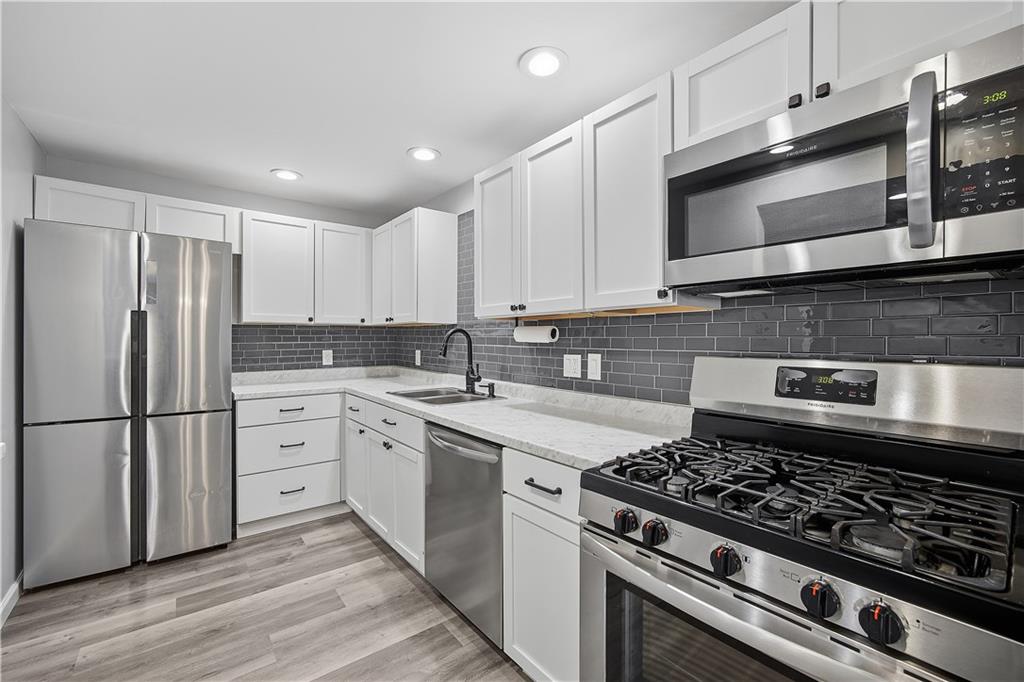 2212 Kenzie Road Pittsburgh, PA 15205 - Photo 12 of 36 a kitchen with cabinets stainless steel appliances and wooden floor