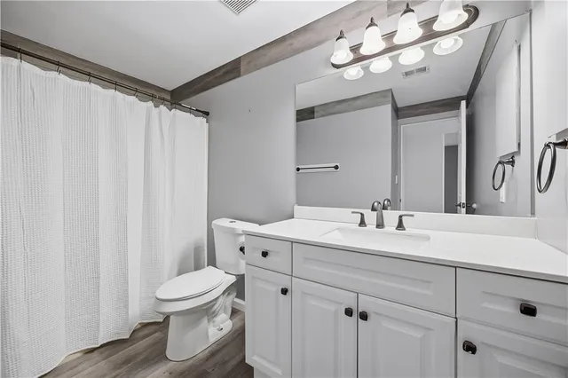 a bathroom with a toilet a sink and a mirror