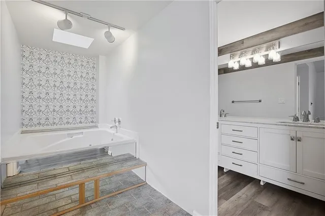 a bathroom with a bathtub and a double vanity sink