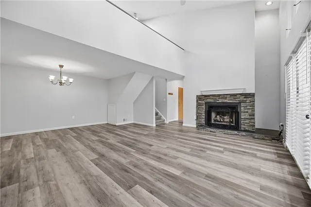 an empty room with wooden floor fireplace and window