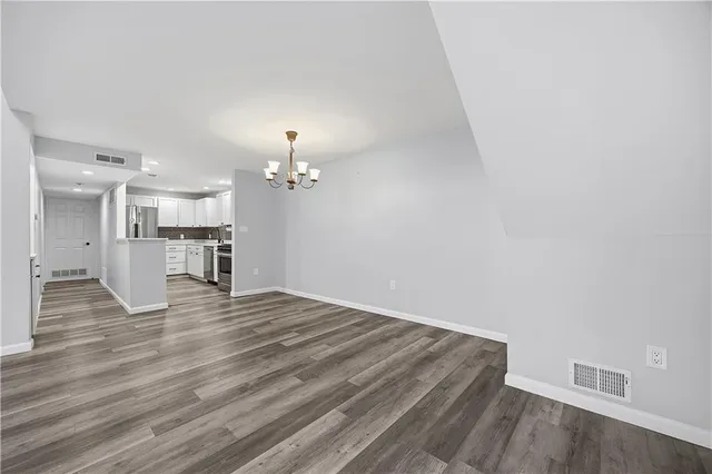 a view of a room with wooden floor and a kitchen