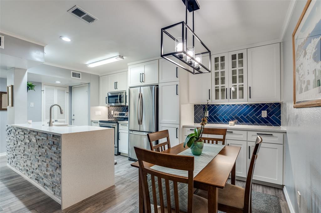 4859 Cedar Springs Road, Unit 261 Dallas, TX 75219 - Photo 1 of 1 a kitchen with stainless steel appliances kitchen island a table chairs in it and wooden floors
