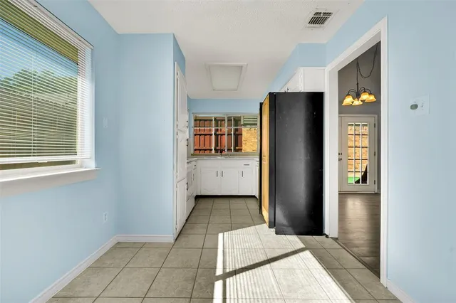 a view of kitchen with windows and refrigerator