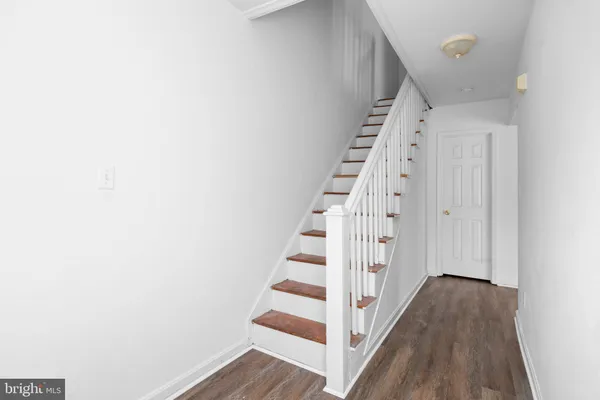 a view of staircase with wooden floor and white walls