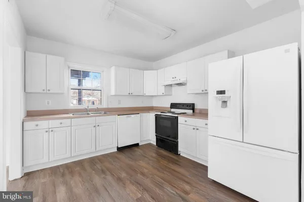 a kitchen with granite countertop white cabinets and white appliances