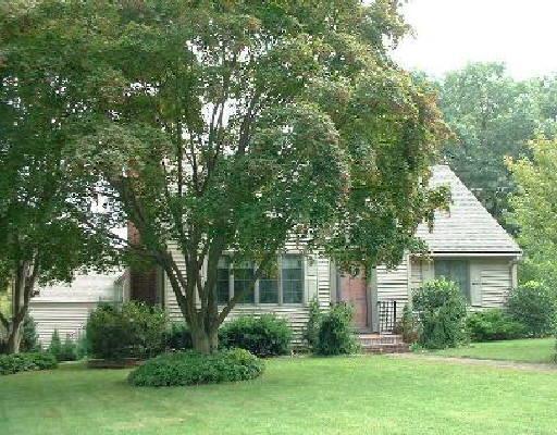 a front view of a house with a yard and trees