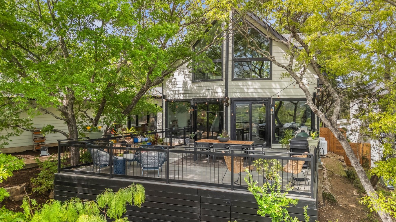 a view of a patio with couches table and chairs under an umbrella