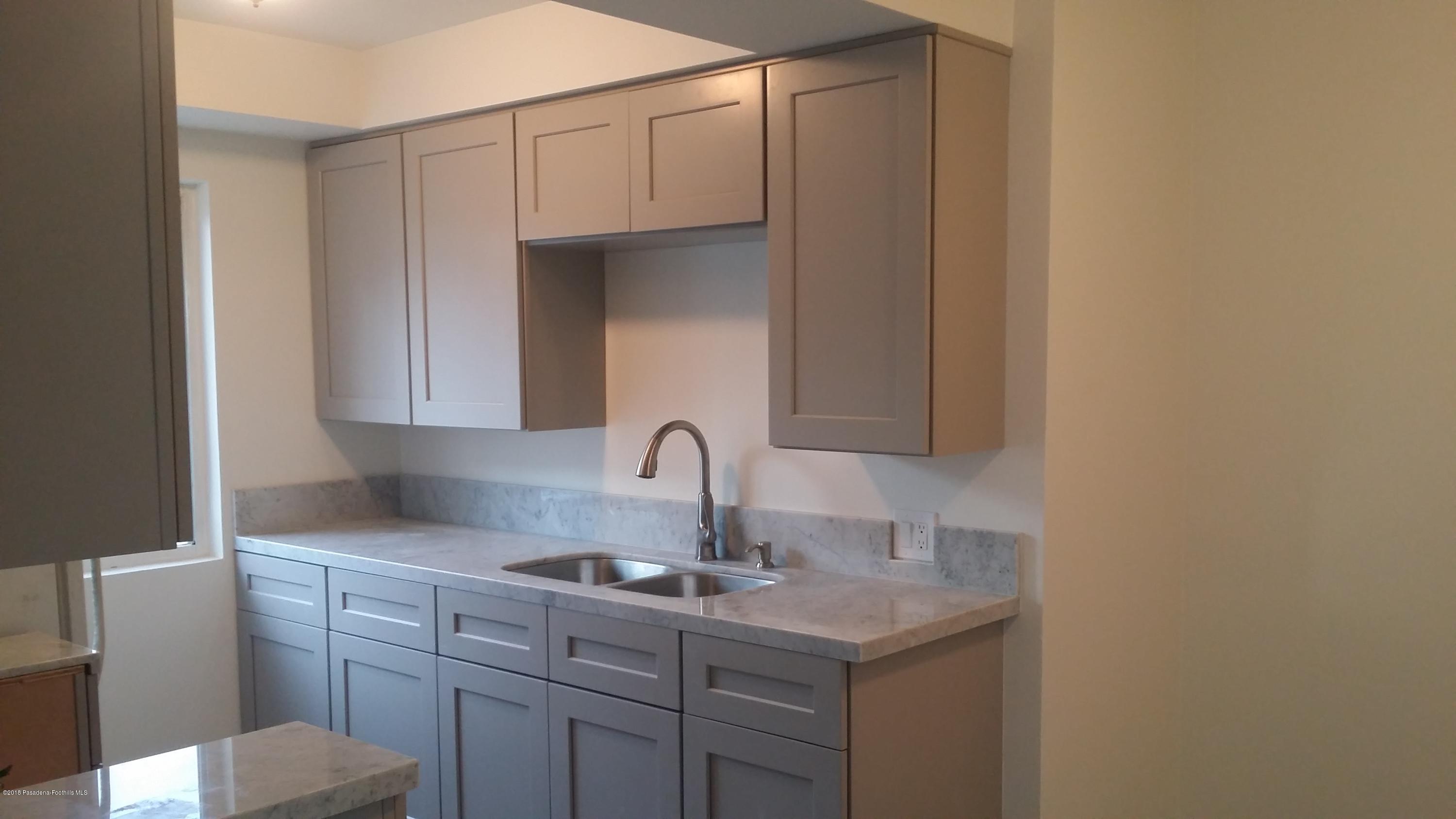 a kitchen with a sink cabinets and a window