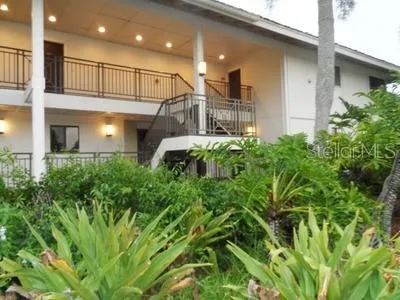 a front view of a house with plants and entryway