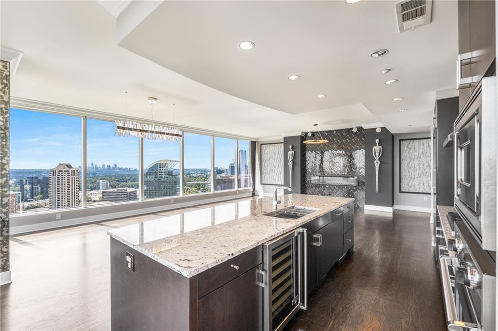 3630 Peachtree Road Northeast, Unit 2404 Atlanta, GA 30326 - Photo 11 of 48 a large kitchen with stainless steel appliances granite countertop a large counter top a stove and a refrigerator