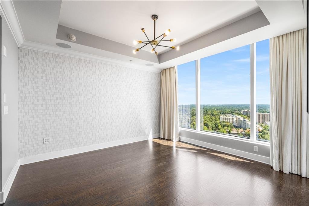 3630 Peachtree Road Northeast, Unit 2404 Atlanta, GA 30326 - Photo 19 of 48 an empty room with wooden floor fan and windows