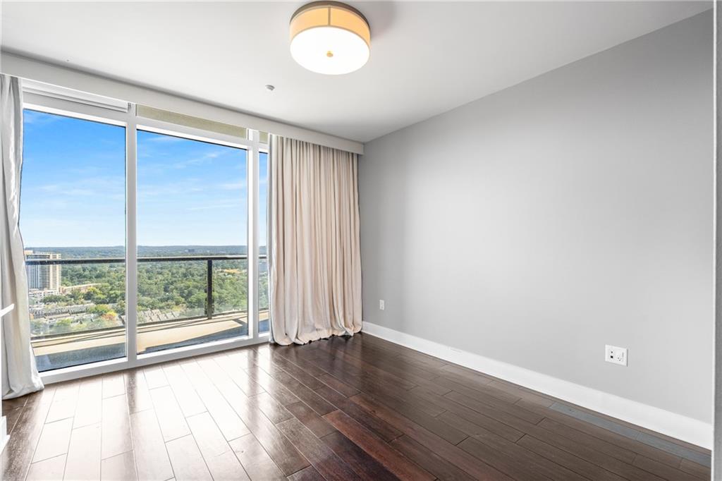 3630 Peachtree Road Northeast, Unit 2404 Atlanta, GA 30326 - Photo 24 of 48 an empty room with wooden floor and windows