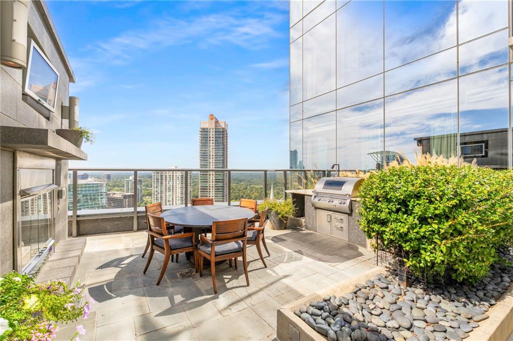 3630 Peachtree Road Northeast, Unit 2404 Atlanta, GA 30326 - Photo 32 of 48 a view of a patio with table and chairs and potted plants