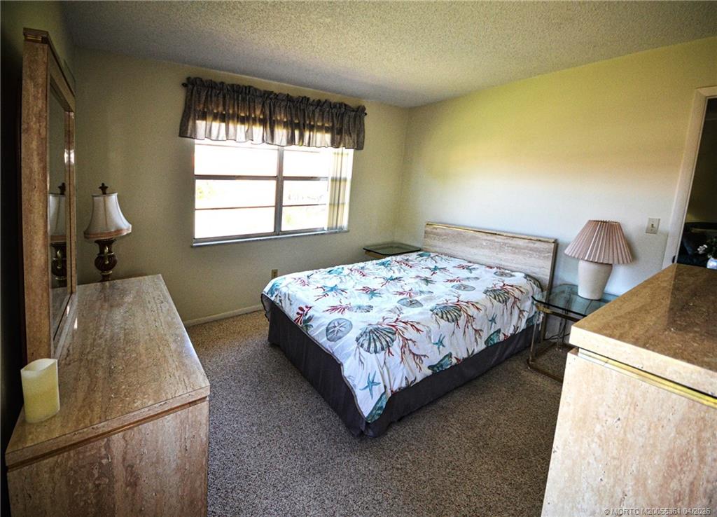 1963 Southwest Palm City Road, Unit F Stuart, FL 34994 - Photo 6 of 9 a bedroom with a bed and window