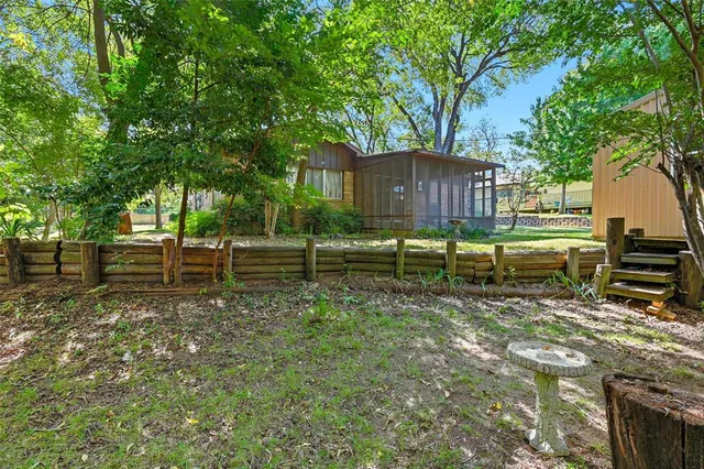 a backyard of a house with lots of green space and fountain in the back