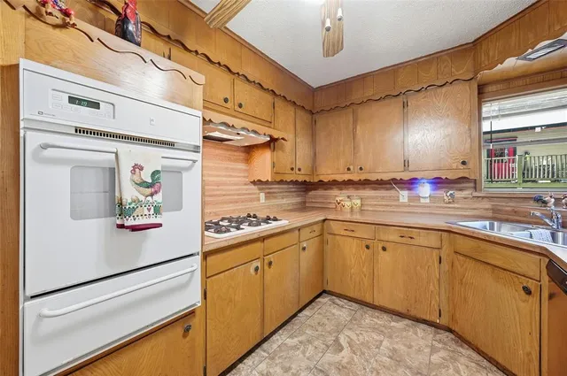 a kitchen with stainless steel appliances a sink cabinets and a window