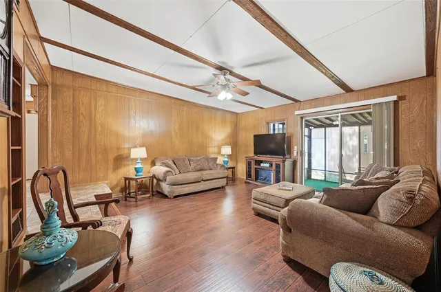 a living room with furniture a large window and a wooden floor