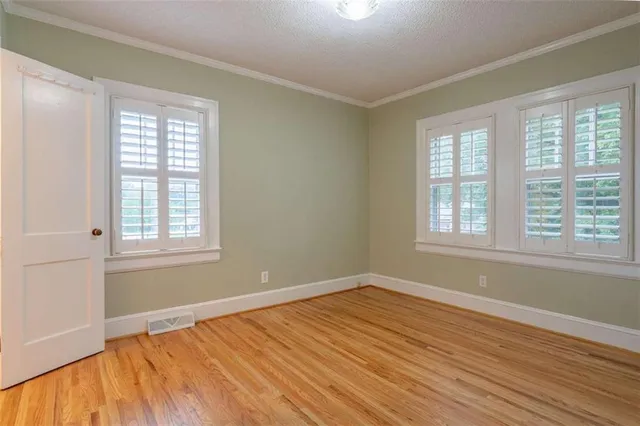 a view of a room with wooden floor and windows in it