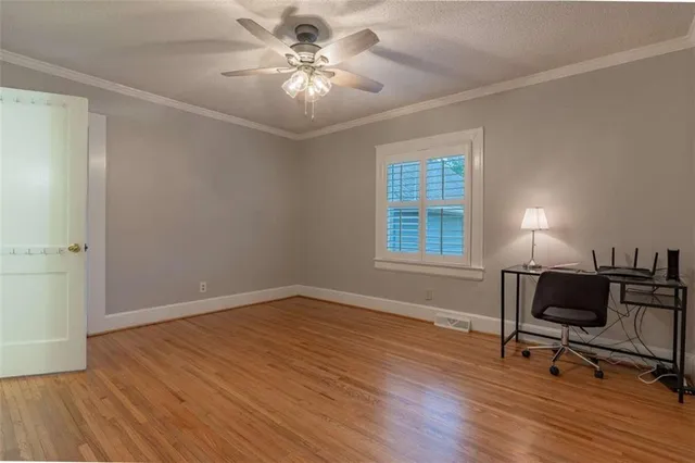 a view of workspace with wooden floor and a window