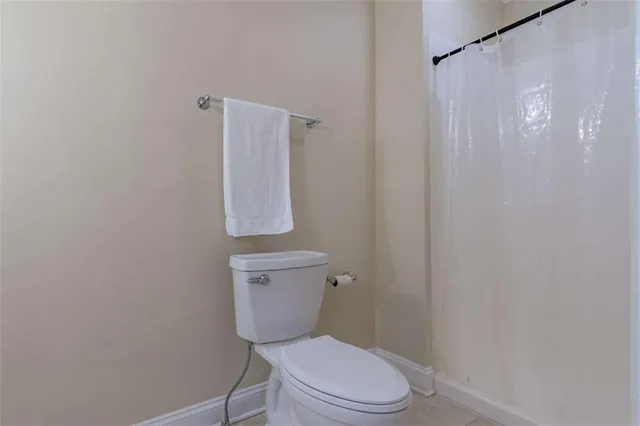 a white toilet sitting next to a shower curtain
