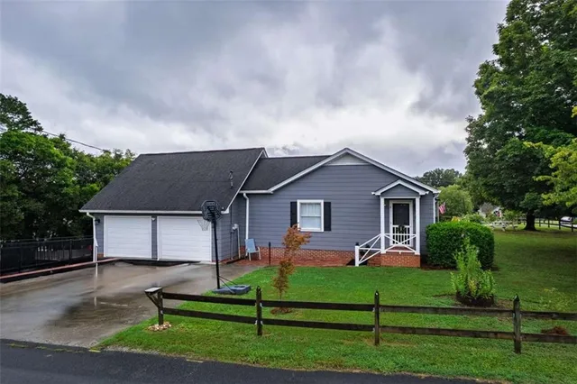 a front view of a house with a yard and trees