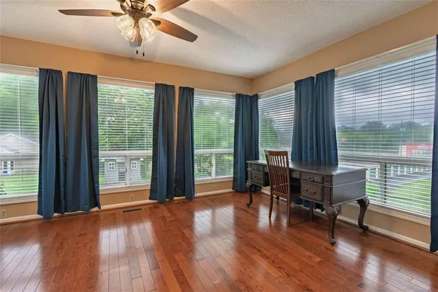 a view of a livingroom with furniture wooden floor and a large window